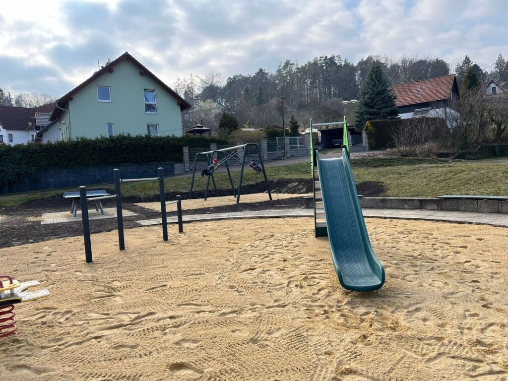 Neuveröffneter Spielplatz Schillerstraße mit Sandplatz, Rutsche, Reck, Schaukeln und Tischtennisplatte
